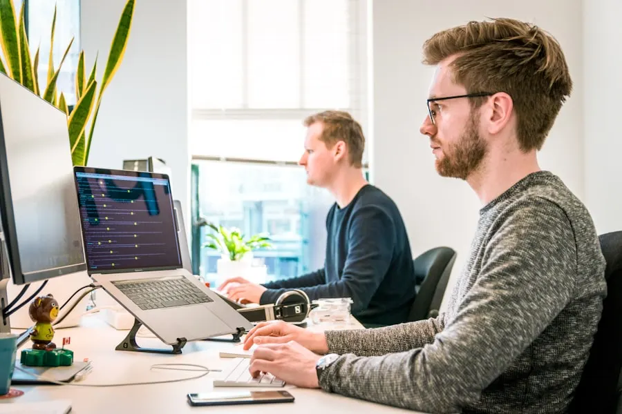Two professionals collaborating in front of screens